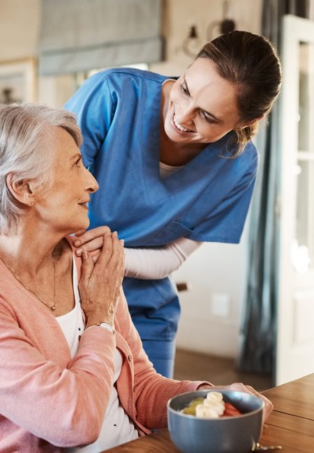 Betreuuerin-beim-Essen-mit-Seniorin